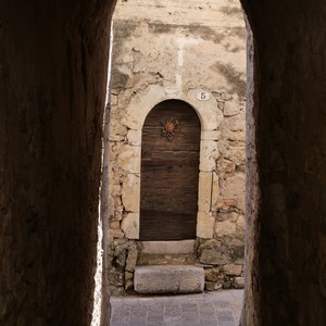 Porche menant à une ruelle face à une porte en bois sur mur de pierres - France  - collection de photos clin d'oeil, catégorie portes